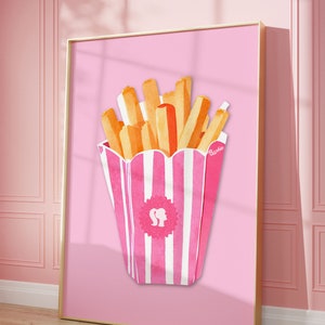 May include: A framed print featuring a watercolor illustration of french fries in a pink and white striped container. The fries are golden brown and orange. The container has a Barbie logo. The background is a solid pink.