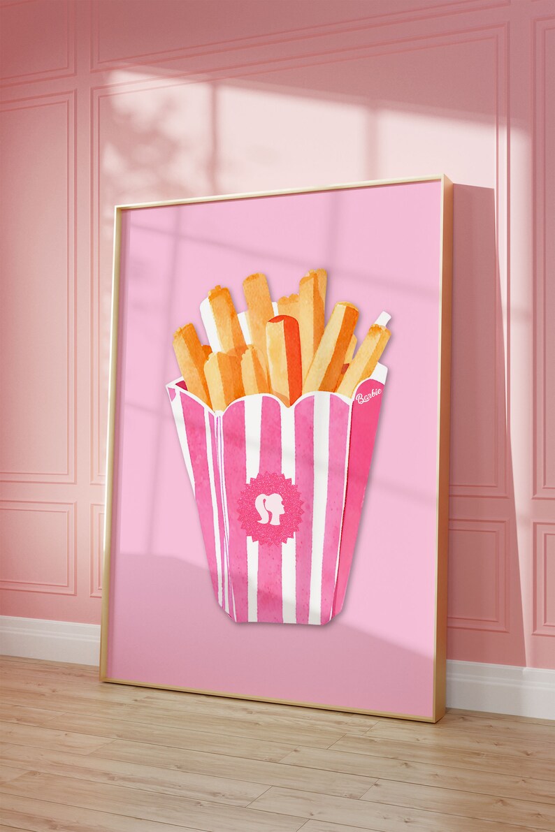May include: A framed print featuring a watercolor illustration of french fries in a pink and white striped container. The fries are golden brown and orange. The container has a Barbie logo. The background is a solid pink.