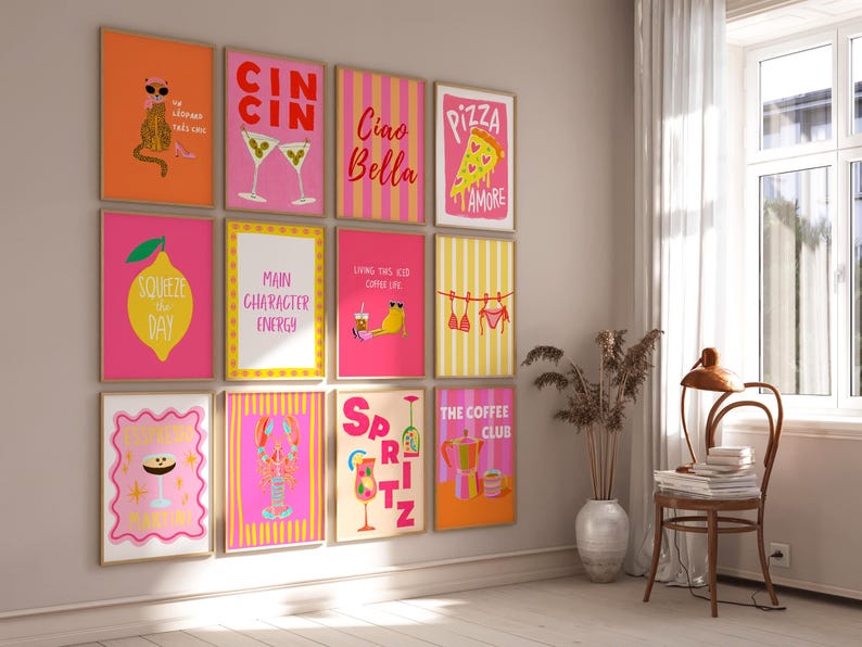 Op de afbeelding: Een verzameling ingelijste kunstprints met kleurrijke illustraties en tekst. De prints tonen verschillende thema's, waaronder cocktails, eten en inspirerende citaten. Het kleurenpalet omvat roze, oranje, geel en wit.