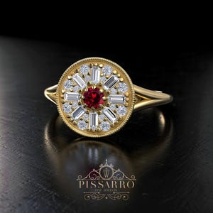 Puede incluir: Un anillo de oro con un diseño circular que presenta una piedra preciosa roja central rodeada de diamantes blancos y piedras de talla baguette. El anillo tiene una banda delicada y está sobre un fondo oscuro. El anillo es de Pissarro Fine Jewelry.