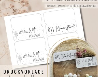 May include: A sheet of white DIY floral bouquet labels with the text "Lass Die Wet Erblühen" and "DIY Blumenstrauß" in black. The labels are rectangular with rounded corners and a small floral design. A clear bag with candies is also visible.