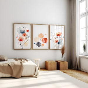 Può includere: Tre dipinti ad acquerello incorniciati con un design minimalista che presenta fiori astratti e cerchi in tonalità di arancione, rosso, blu e grigio.