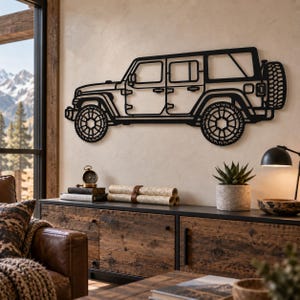 May include: A black metal wall art piece shaped like the side profile of a four-door off-road vehicle. The design features detailed outlines of the windows, doors, large rugged tires, and a spare tire mounted on the rear of the vehicle frame.