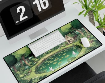 May include: A green and brown illustrated mousepad with a pond, a small house, and two white rabbits. The mousepad is on a white desk with a computer monitor and a keyboard.