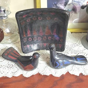 May include: A white ceramic mug with a black handle and the text "But First, Coffee" in a black, bold font. The mug is on a white surface.