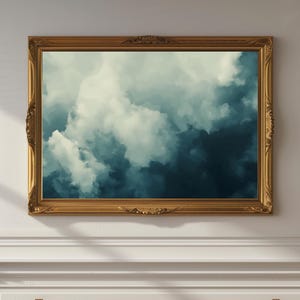 May include: A framed abstract painting of a blue and white cloudy sky. The frame is gold and ornate.