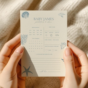Może przedstawiać: Kremowa karta z ogłoszeniem narodzin dziecka z niebieskimi ilustracjami muszli i koralowców. Karta zawiera tekst "Baby James" i miejsca na dane dotyczące urodzenia, w tym miesiąc urodzenia, datę, godzinę, wagę i długość. Karta jest trzymana przez osobę.