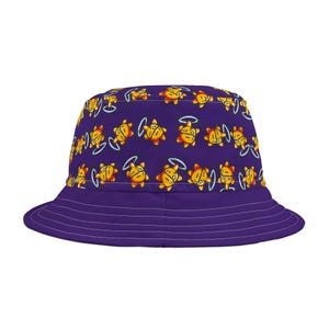 May include: Purple bucket hat with a repeating pattern of yellow cartoon suns with halos. The hat has a wide brim and is made of a soft fabric. The hat is a stylish accessory for sunny days.