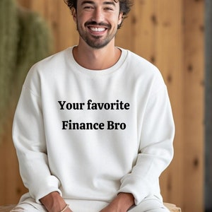 Può includere: Felpa bianca con collo a girocollo con la scritta "Your favorite Finance Bro" stampata sul davanti.