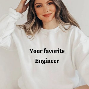 以下が含まれることがあります： 前面に「Your favorite Engineer」という文字が印刷された白いスウェットシャツです。