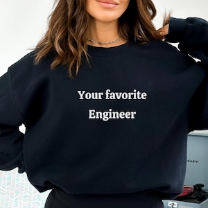 以下が含まれることがあります： 白文字で「Your favorite Engineer」と書かれた黒のクルーネックのスウェットシャツ。スウェットシャツは無地で、クラシックでカジュアルなスタイルです。エンジニアへのプレゼントに最適です。