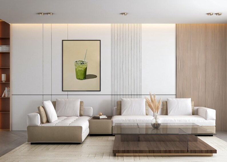 May include: A white sectional sofa with beige cushions sits in a modern living room with a wood slat wall and a framed print of a green drink with a straw.