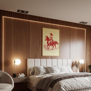 May include: A bedroom with a wooden accent wall and a large white bed. A framed print of a cowgirl on a horse hangs above the bed. A modern, minimalist design with a neutral color palette.
