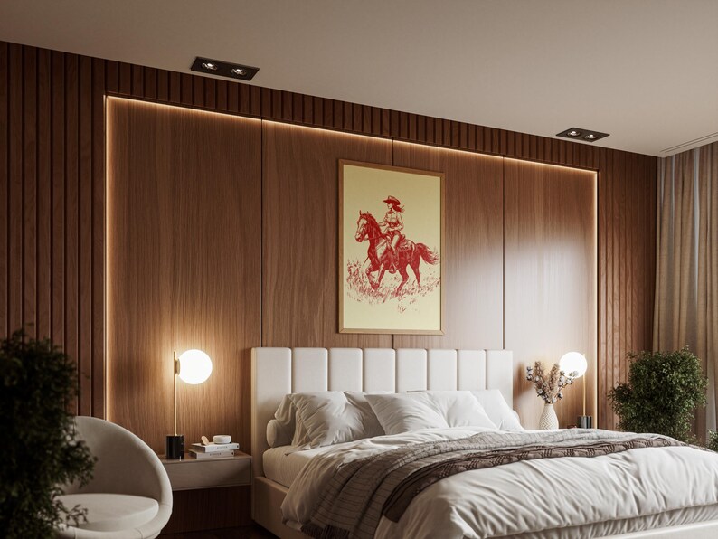 May include: A bedroom with a wooden accent wall and a large white bed. A framed print of a cowgirl on a horse hangs above the bed. A modern, minimalist design with a neutral color palette.