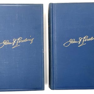 May include: Two matching hardcover books with deep blue fabric covers. Each front cover features the gold embossed signature of John J. Pershing centered in the middle. The books have a rectangular border design pressed into the front covers.