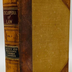 Puede incluir: Un libro de derecho antiguo, "Cyclopedia of Law, Vol. V", con una cubierta desgastada y texturizada. El lomo es de color marrón oscuro con letras doradas y una etiqueta burdeos. La cubierta del libro es de color beige claro.
