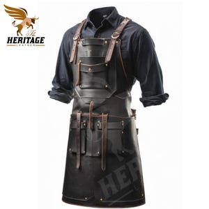Könnte beinhalten: Eine schwarze Lederschürze mit mehreren Taschen und Riemen. Die Schürze hat einen braunen Lederbesatz und wird über einem blauen Hemd getragen.