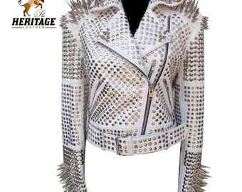 May include: White leather jacket with silver studs and spikes. The jacket has a zipper closure and a belt.