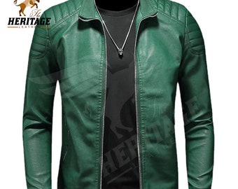 May include: A green leather jacket featuring a stand-up collar, a silver front zipper, and quilted shoulder panels. The jacket is worn over a black shirt with a silver skull pendant necklace. The logo for The Heritage Leather is visible.