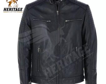 May include: A black jacket featuring a stand-up collar with a snap button, a central zip closure, and two horizontal zipped chest pockets. The shoulders and upper sleeves have ribbed detailing, and two vertical zipped pockets are at the waist.