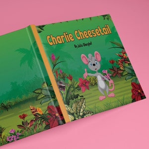 May include: A green and brown book cover with a cartoon mouse on the front. The book is titled "Charlie Chesetail" by Julia Gheorghe.