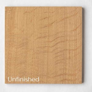 May include: A square, unfinished piece of light brown wood with visible grain patterns. The text "Unfinished" is printed in white at the bottom left corner of the wood. The wood has a natural, warm tone.