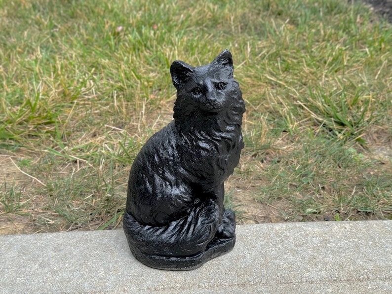Peut inclure: Une figurine de chat en c&eacute;ramique noire avec une queue touffue et une pose assise. Le chat a une apparence r&eacute;aliste avec une fourrure et des traits du visage d&eacute;taill&eacute;s.