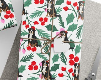 May include: Gift-wrapped presents with a festive dog-themed wrapping paper featuring a Bernese Mountain Dog design, holly, and red berries. Tied with twine and adorned with white star-shaped tags. Includes a spool of twine and scissors.