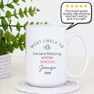 May include: White ceramic mug with a large handle. The mug features the text "MOST LIKELY TO Declare Mahjong and be WRONG Jennifer 2025". A speech bubble says "This mug is great! Quality was amazing and can't wait to give it as a gift".