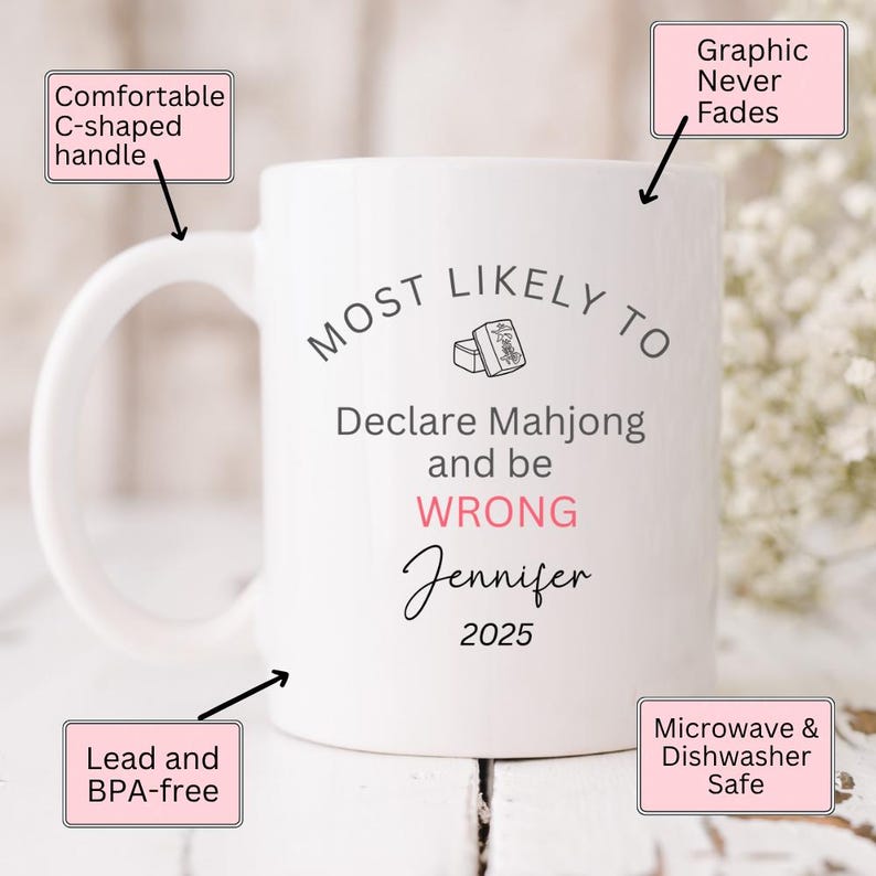 May include: White ceramic mug with a comfortable C-shaped handle. The mug features the text "MOST LIKELY TO Declare Mahjong and be WRONG Jennifer 2025". The mug is lead and BPA-free, and microwave and dishwasher safe.
