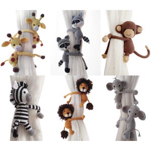 Puede incluir: Una colección de seis sujetacortinas de animales de ganchillo. Los animales incluyen una jirafa, un mapache, un mono, una cebra, un león y un elefante. Cada animal es de un color diferente y sujeta una cortina blanca.