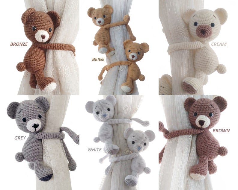 May include: Set of six crocheted teddy bear curtain tie backs in various colours: bronze, beige, cream, grey, white, and brown. Each bear is holding onto a curtain with its paws.