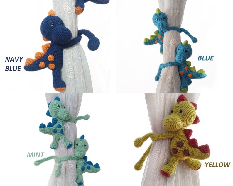 May include: Set of four crocheted dinosaur curtain tie backs in navy blue, blue, mint green, and yellow. Each dinosaur has orange spots and a curled tail.