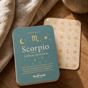 May include: A teal deck of Mantra Minis Scorpio zodiac mantra cards with gold text and star symbols, featuring the words Mantra Minis, Scorpio, ZODIAC MANTRAS, and INTUITIVE REMINDERS FOR THE SLIGHTLY INTENSE, & EMOTIONALLY OBSERVANT by finch road STUDIOS.