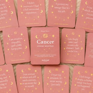 Könnte beinhalten: Eine Sammlung rechteckiger Cancer Zodiac Mantra-Karten in Altrosa mit goldenen Himmelsgrafiken. Jede Karte enthält einen einzigartigen Text, wie zum Beispiel 'I didn't overreact. I had a full emotional experience' und 'I protect my energy like it's my job.'