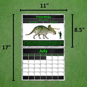 Total Dino's 2027 wall calendar July featuring Triceratops, displaying measurements of 11 x 17 inch full spread, with 8.5 inch top section