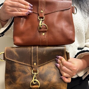 Bison leather crossbody sling bag for women, two brown-toned bags with adjustable straps and brass hardware.