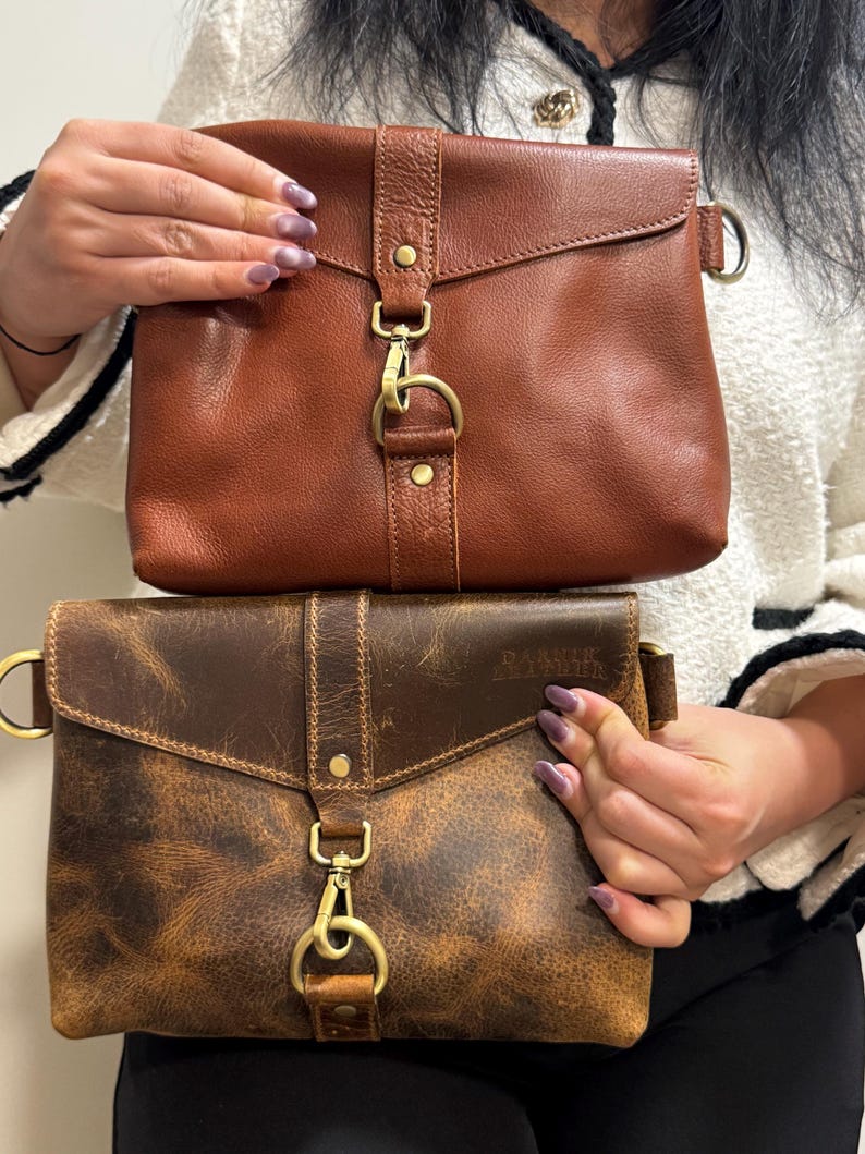 Bison leather crossbody sling bag for women, two brown-toned bags with adjustable straps and brass hardware.