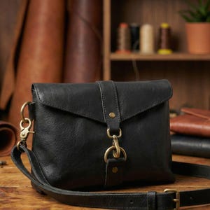 Black bison leather crossbody sling bag for women with flap and adjustable strap, handmade.