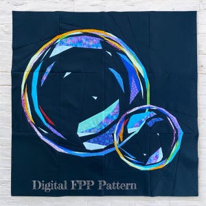 Peut inclure: Une courtepointe bleu foncé représentant deux grands cercles superposés avec des motifs géométriques colorés. Les cercles sont soulignés de teintes arc-en-ciel. Le texte "Digital FPP Pattern" est en bas.