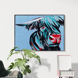May include: A rectangular wall art piece featuring a geometric, stylized portrait of a Highland cow. The cow is rendered in shades of blue, black, and white with bright red accents on the eyes and nose, set against a light blue textured background.
