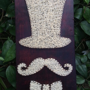 May include: A white ceramic mug with a black handle and the text "But First, Coffee" in a bold, black font. The mug is set against a neutral background, highlighting its simple design.