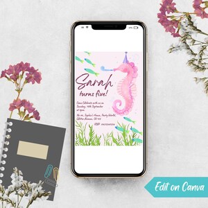 May include: A smartphone displays a birthday invitation with a pink seahorse illustration. The text reads "Sarah turns five!" with event details. The phone is surrounded by flowers and a notebook.