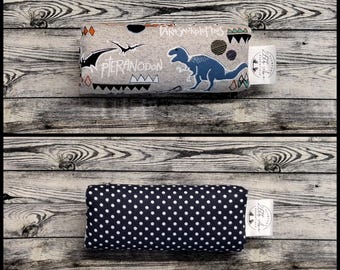 May include: A rectangular fabric pouch featuring a gray side with blue dinosaur illustrations, the text Pteranodon and Parasaurolophus, and a white tag. The reverse side is dark blue with a white polka dot pattern and a white brand tag.