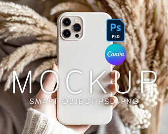 May include: White iPhone mockup with a white case, held in a hand wearing a white sweater. The phone has a camera bump with four lenses. The text "MOCKUP" is written in white on a black background below the phone. The text "SMART OBJECT PSD + PNG" is written in white on a black background below the text "MOCKUP".