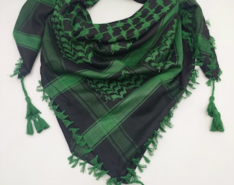 May include: A black and green patterned headscarf with tassels. The scarf has a traditional geometric design and is made of a soft, lightweight fabric.