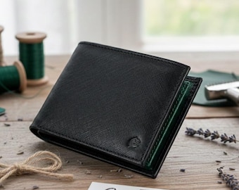 Puede incluir: Cartera de cuero negro con un acabado texturizado y un interior verde. La cartera está abierta, revelando el interior. El fondo incluye carretes de hilo, un lazo y lavanda, lo que sugiere un tema artesanal.