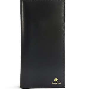 May include: A tall, rectangular black leather wallet with a smooth finish and visible stitching along the right edge. In the bottom right corner, there is a small yellow logo of a horse head silhouette above the text Kordovan in yellow font.