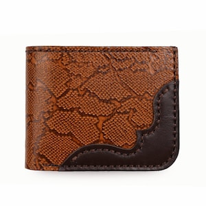 May include: A brown leather wallet with a textured, snake-skin pattern. The wallet has a dark brown accent on the corner and is stitched with dark brown thread. The wallet is rectangular in shape.