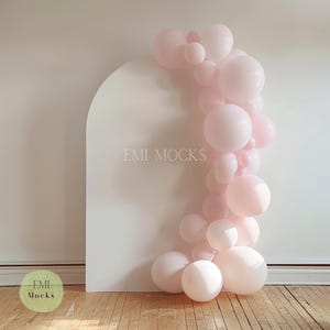 Peut inclure: Une arche blanche en arrière-plan avec une guirlande de ballons roses. La guirlande est composée de ballons de différentes tailles, tous de couleur rose clair. L'arrière-plan est une surface simple et propre, idéale pour présenter des produits ou créer un fond de photo.